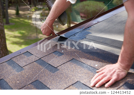Worker's hands are smeared with waterproofing mastic for the roof. 124413452