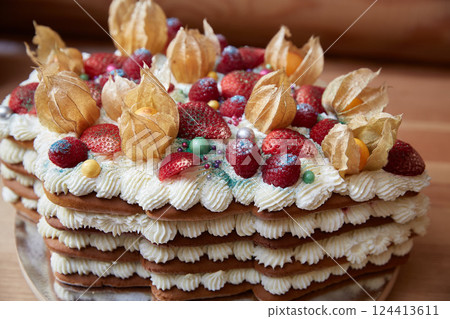 Strawberries and raspberries on a cake with whipped cream. 124413611