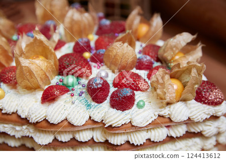 Strawberries and raspberries on a cake with whipped cream close-up 124413612