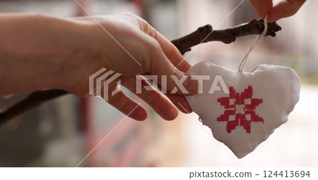 Handcrafted heart ornament created with care, showcasing intricate design and detail, displayed outdoors in a natural setting to enhance its beauty during a sunny afternoon 124413694