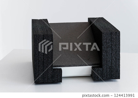 Close Up View of Black Protective Foam Packaging Securing White Object 124413991