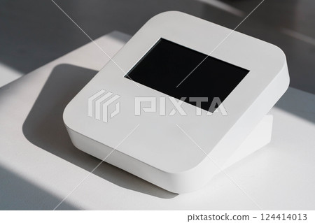 Modern Minimalistic White Digital Touchscreen Device on Table with Sunlight Shadows Modern Minimalistic White Digital Touchscreen Device on Table with Sunlight Shadows 124414013