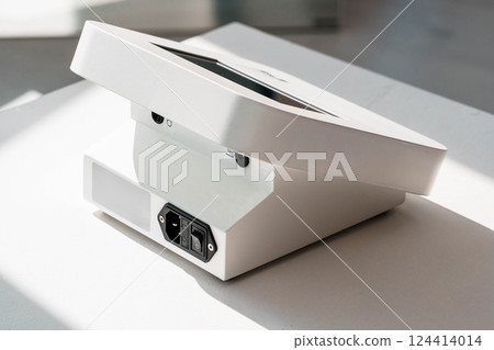 Modern White Electronic Device with Open Lid Featuring Power Switch and Connector on Minimalistic Background Modern White Electronic Device with Open Lid Featuring Power Switch and Connector on Minimalistic Background 124414014