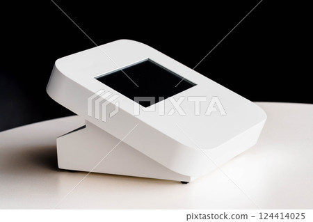 Modern White Digital Device with Minimalist Design and Touchscreen Display on a Table Modern White Digital Device with Minimalist Design and Touchscreen Display on a Table 124414025