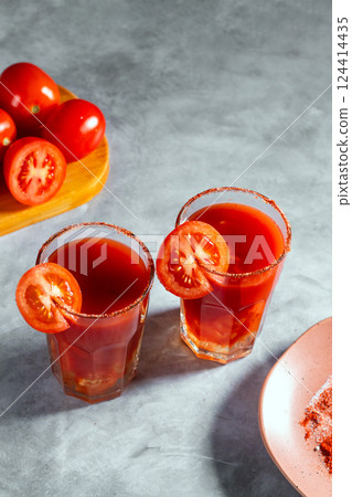 Top view shot of two refreshing vegetable cocktails. Red cocktail. Tomato juice served in glass with tomato slice. Image for menu, bars, restaurants Top view shot of two refreshing vegetable cocktails. Red cocktail. Tomato juice served in glass with tomato slice. Image for menu, bars, restaurants 124414435