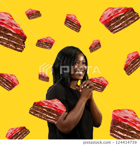 Smiling woman surrounded by chocolate cherry cakes against bright yellow background. Food pop art photography. 124414739