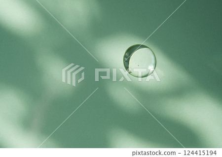 A drop of micellar water on a green background. 124415194