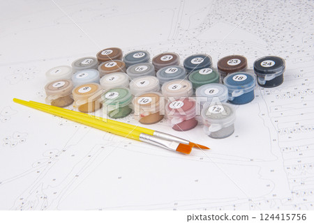 A set of colorful gouache paints, brushes and canvas with numbers is ready for drawing education. Hobby and leisure activity. Background with copy space 124415756