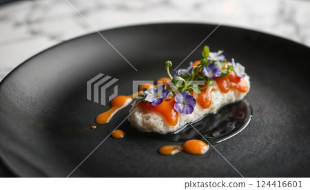 Culinary Artistry: A gourmet delight, meticulously arranged on a sleek, dark plate, this exquisite creation combines textures and flavors, adorned with vibrant edible flowers and artful sauce. 124416601