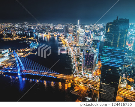 night view of illuminated Ho Chi Minh city skyline and Saigon river, neon street lights of financial downtown district with tall skyscraper towers, Vietnam aerial drone view 124416730
