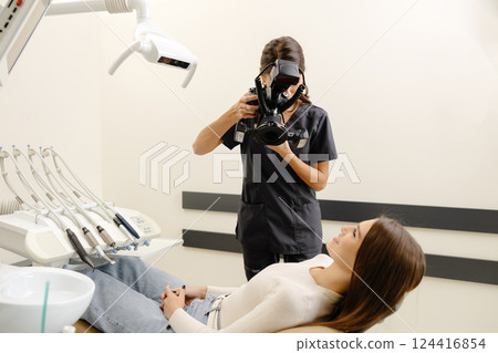 Dentist woman photographing with professional camera the result of her work in clinic 124416854