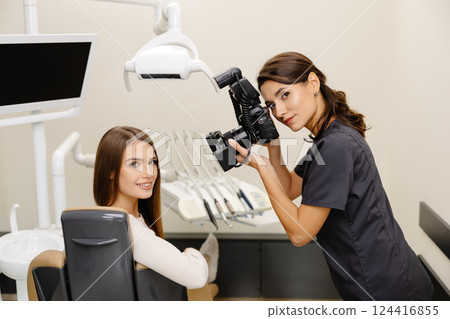 Dentist woman photographing with professional camera the result of her work in clinic 124416855