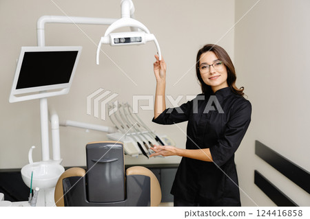 Portrait of young female dentist in modern clinic. A female dentist kindly invites you to an appointment 124416858