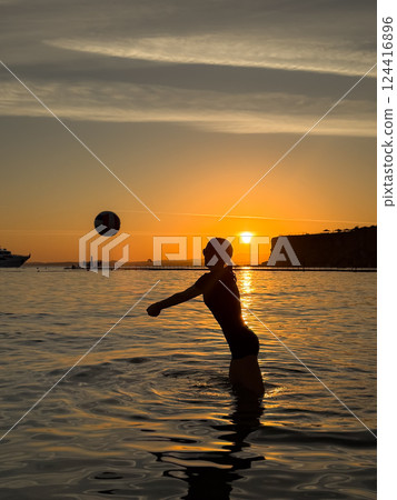 Silhouette of young girl playing volleyball at the beach 124416896