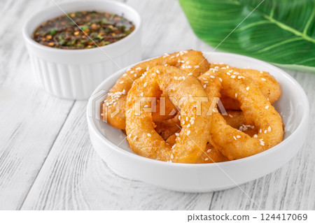 Crispy battered calamari rings with sesame seeds and spicy Asian dipping sauce 124417069