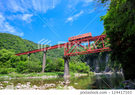 從河岸仰望越美北線橙色柴油列車穿過第二九頭龍川大橋 124417103