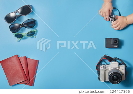 Creative concept of a flat trip with cameras, sunglasses and passports for a family of three. The concept of planning a family vacation or trip. Copy space 124417566