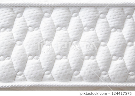 Large white mattress with stitched finishing lines. Close-up. Side view. Large white mattress with stitched finishing lines. Close-up. Side view. 124417575