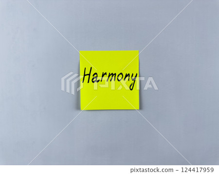 Sticky note with the word Harmony written on it, pinned on white background. Photo symbolizes peace, balance, and unity. Ideal for illustrating concepts of harmonious relationships and balanced life 124417959