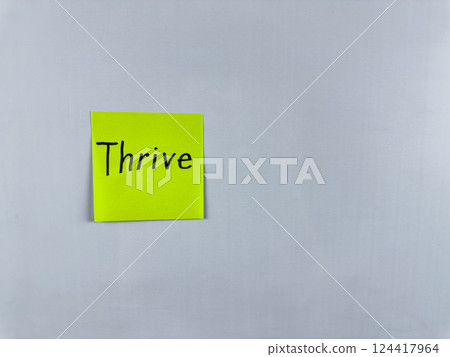 Sticky note with Thrive written on it, affixed to a white background. This image represents flourishing and success, perfect for themes of personal growth and thriving in life 124417964