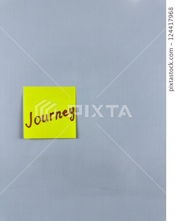 Sticky note with Journey written on it, affixed to a white background. This image represents travel and exploration, ideal for themes of journeys in life and adventure 124417968
