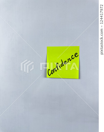 Sticky note with Confidence written on it, affixed to a white background. This image represents self assurance and trust, ideal for themes of confidence in life and professional settings 124417972