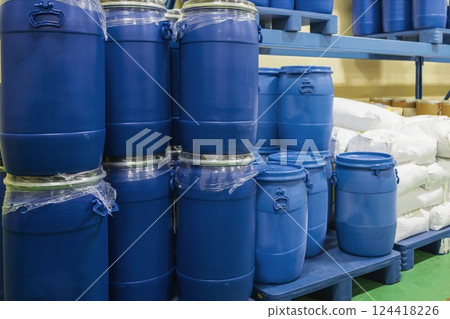 Closeup view of barrels stacked on top of each other. Blue plastic tanks on pallets in a chemical warehouse 124418226