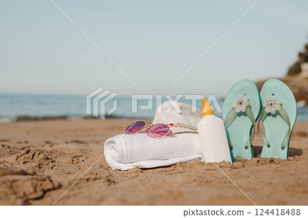 Beach accessories relaxation scene with sandals,sunglasses,hat and towel Beach accessories relaxation scene with sandals,sunglasses,hat and towel 124418488