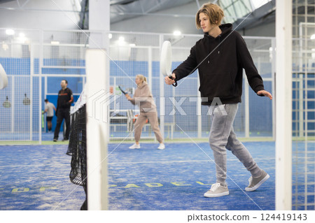 Young boy with racquet playing padel Young boy with racquet playing padel 124419143