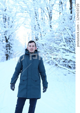 A person enjoying a beautiful winter landscape among the trees that are covered in snow A person enjoying a beautiful winter landscape among the trees that are covered in snow 124419720