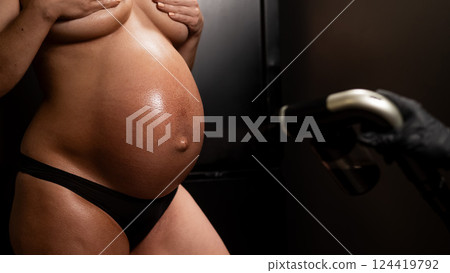 Faceless pregnant woman getting an instant tan. The master applies bronzer with a spray. Faceless pregnant woman getting an instant tan. The master applies bronzer with a spray. 124419792