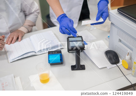 A narcologist tests urine for drugs using an electronic device. A narcologist tests urine for drugs using an electronic device. 124419849