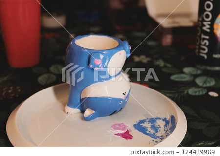 A beautifully designed Cute Blue Whale Mug resting elegantly on a decorative Plate 124419989