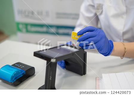 A narcologist tests urine for drugs using an electronic device.  A narcologist tests urine for drugs using an electronic device.  124420073