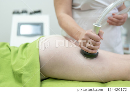 Caucasian woman on hardware anti-cellulite massage. Thigh cavitation procedure. Caucasian woman on hardware anti-cellulite massage. Thigh cavitation procedure. 124420172