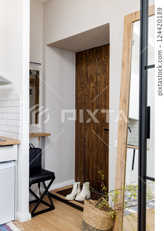 A modern entryway featuring a wood accent combined with a minimalist design aesthetic 124420189