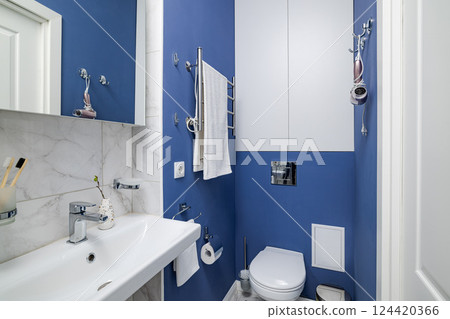 A beautifully designed modern compact bathroom showcasing blue accents alongside elegant fixtures 124420366
