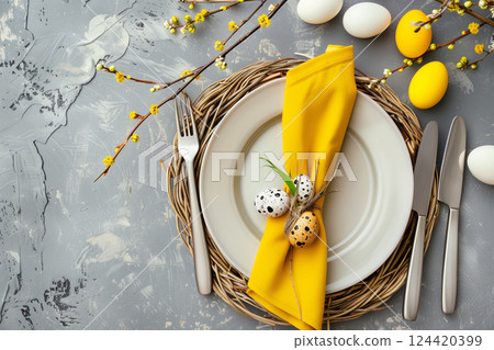 Elegant spring table setting with yellow napkin and quail eggs for easter celebration 124420399
