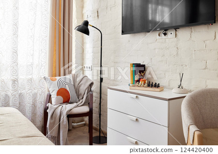 A cozy and modern living space featuring a flatscreen TV and comfortable seating options 124420400