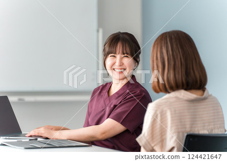 A female patient and a doctor, nurse, and counselor having a medical examination, consultation, and counseling at a hospital 124421647