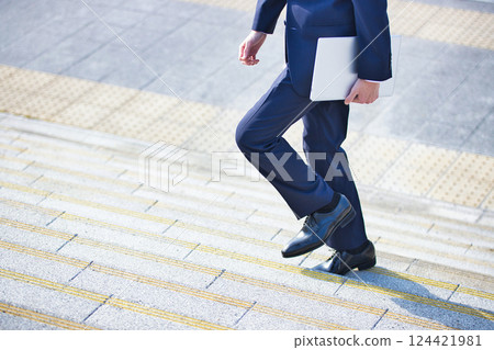 Business image: A young man walking with a computer 124421981