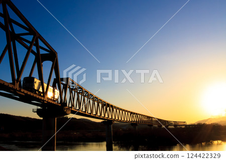 Ibara Railway diesel railcar crossing the Takahashi River Bridge in the setting sun Ibara Railway diesel railcar crossing the Takahashi River Bridge in the setting sun 124422329