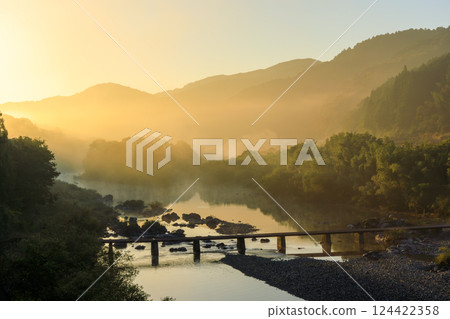 清晨的陽光灑在橫跨日本最後一條清澈河流四萬十川的向廣瀨海底橋上。 清晨的陽光灑在橫跨日本最後一條清澈河流四萬十川的向廣瀨海底橋上。 124422358