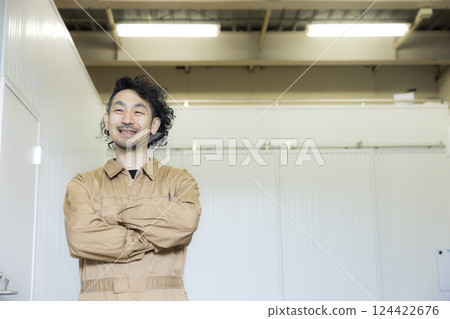 A man in overalls walking through a warehouse A man in overalls walking through a warehouse 124422676