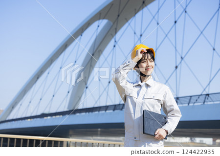 Woman in work clothes at a construction site Woman in work clothes at a construction site 124422935