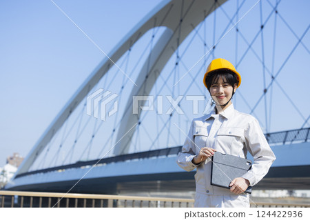 Woman in work clothes at a construction site Woman in work clothes at a construction site 124422936