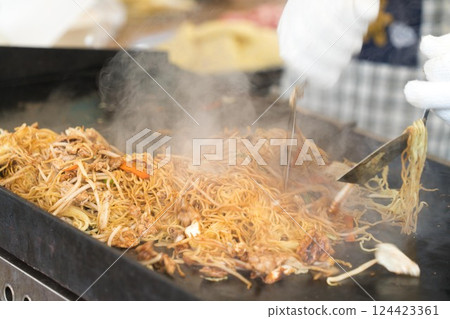 A large amount of yakisoba being grilled at a stall A large amount of yakisoba being grilled at a stall 124423361