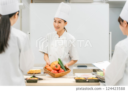 A female instructor who teaches at cooking seminars, vocational schools, and employee training 124423588
