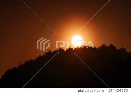 Wind blowing across the lake surface. The sun setting behind the mountain on the opposite shore at Nara Nunome Dam in spring 2025. 124424273