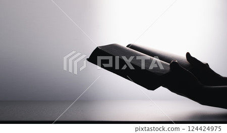 Hands in prayer on holy bible in church concept for faith, spirituality and religion. Unrecognizable woman holding a bible in her hands and praying. Hands clasped in prayer over holy bible. Hands in prayer on holy bible in church concept for faith, spirituality and religion. Unrecognizable woman holding a bible in her hands and praying. Hands clasped in prayer over holy bible. 124424975